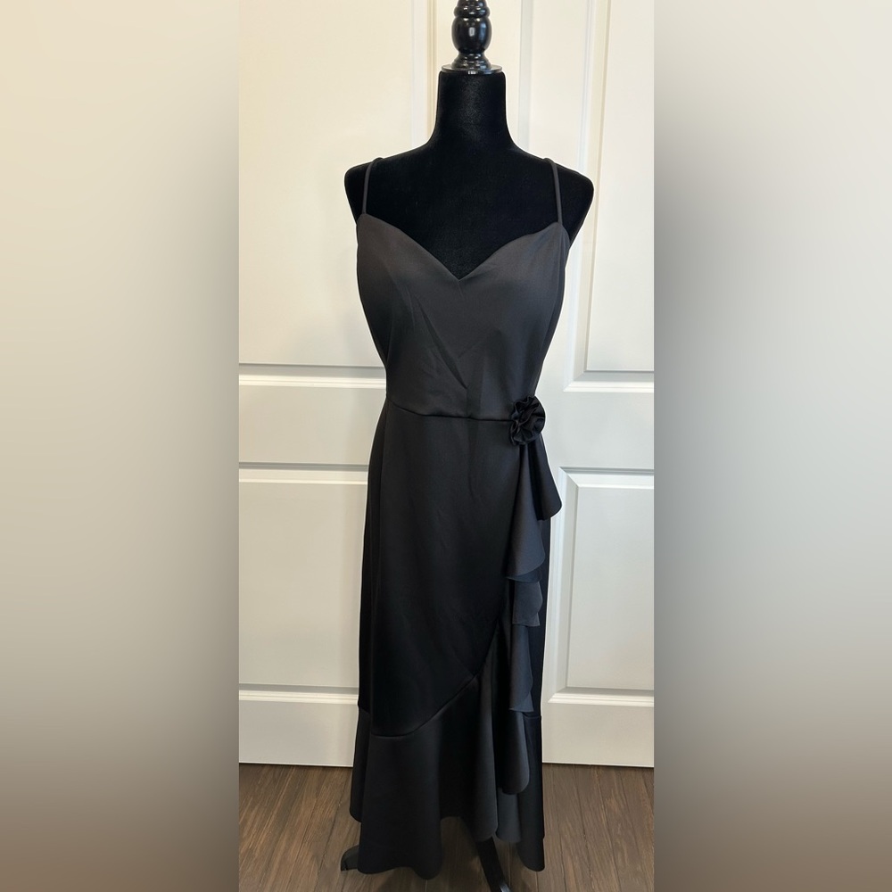 Black evening dress with flower detail and ruffles.